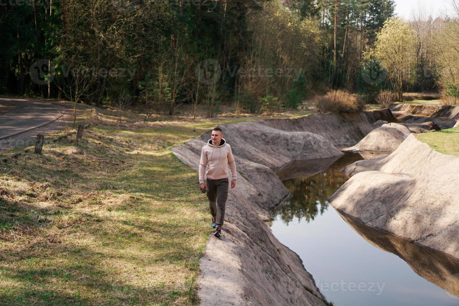 um jovem em um terno confortável caminha pela floresta foto