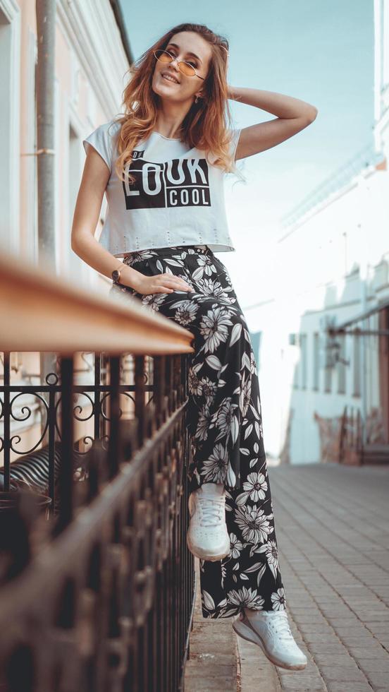 retrato da moda elegante mulher bonita em óculos de sol, posando na cidade foto