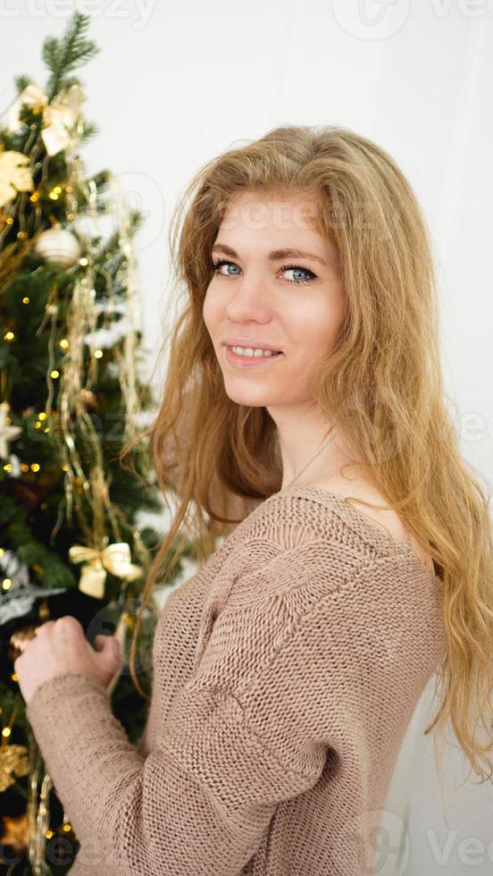 bela jovem decorando uma árvore de natal foto