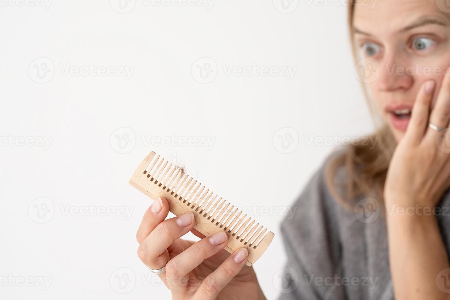 mulher escovando o cabelo sofrendo de calvície foto