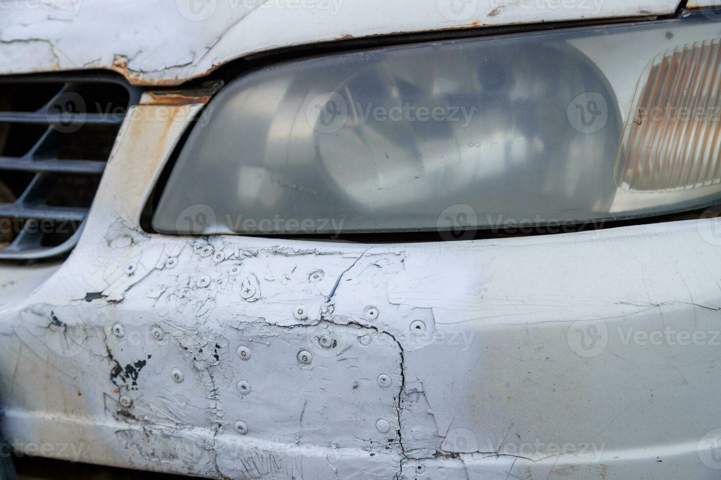 velho branco carro Parachoque negligentemente fixo com remendos e rebites e pintado sobre com pode do tinta spray, fechar-se Visão foto