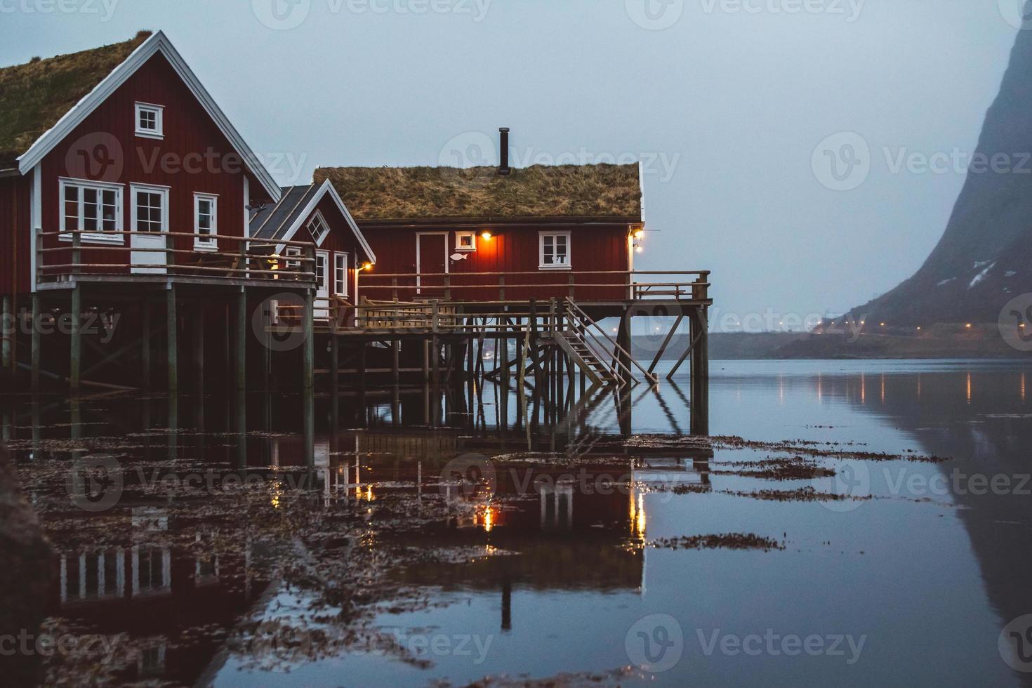 casas rorbu da noruega e rochas de montanhas sobre o fiorde foto