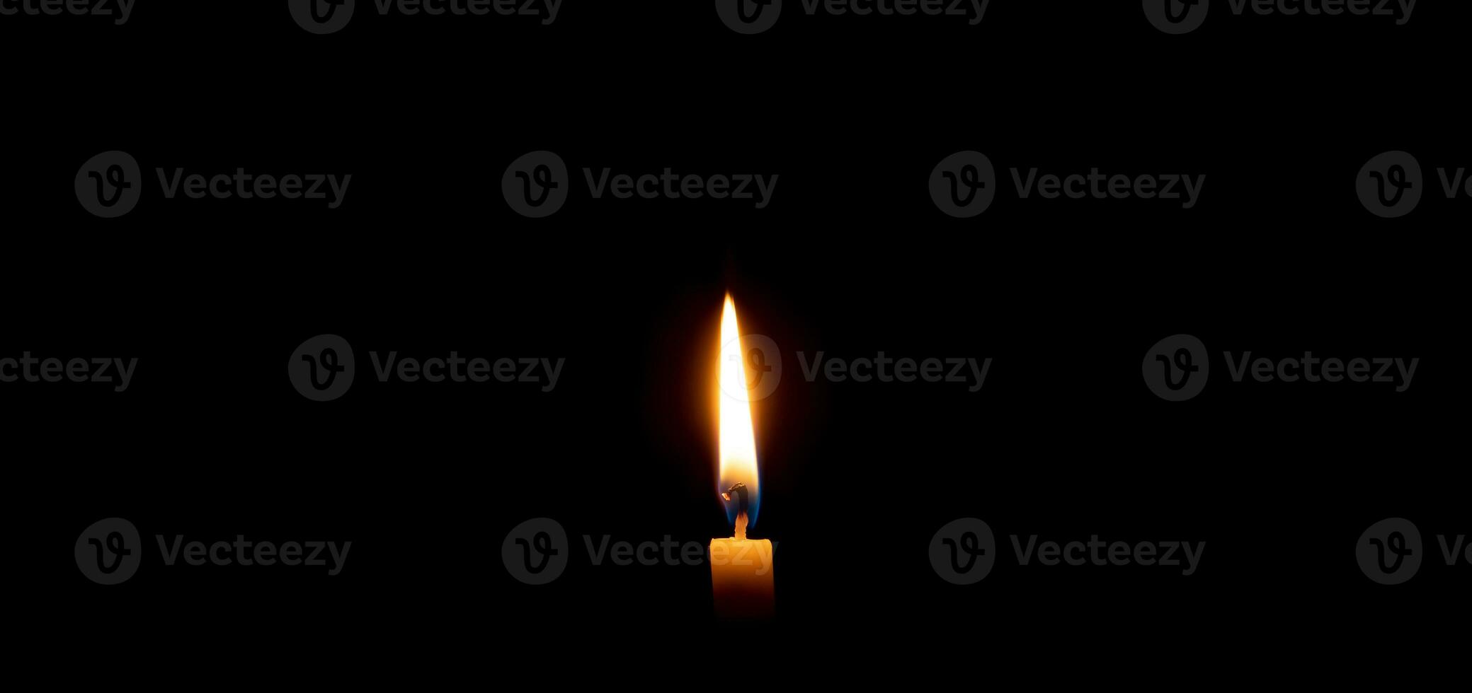 solteiro queimando vela chama ou luz brilhando em uma pequeno amarelo vela em Preto ou Sombrio fundo em mesa dentro Igreja para Natal, velório ou memorial serviço com cópia de espaço foto