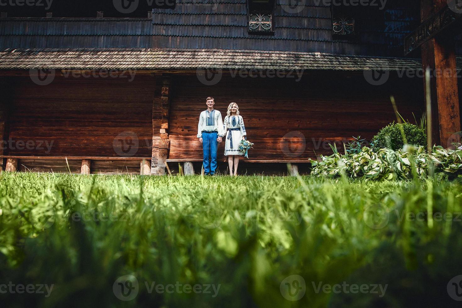 casal fora de uma casa de madeira foto