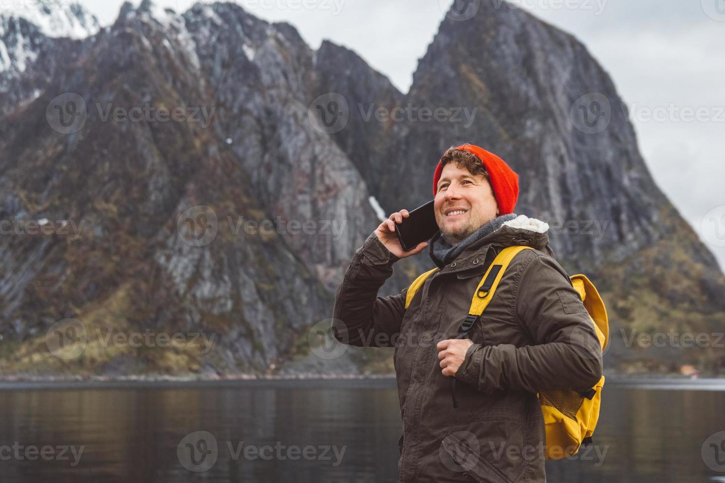 homem falando ao telefone com uma mochila na natureza foto