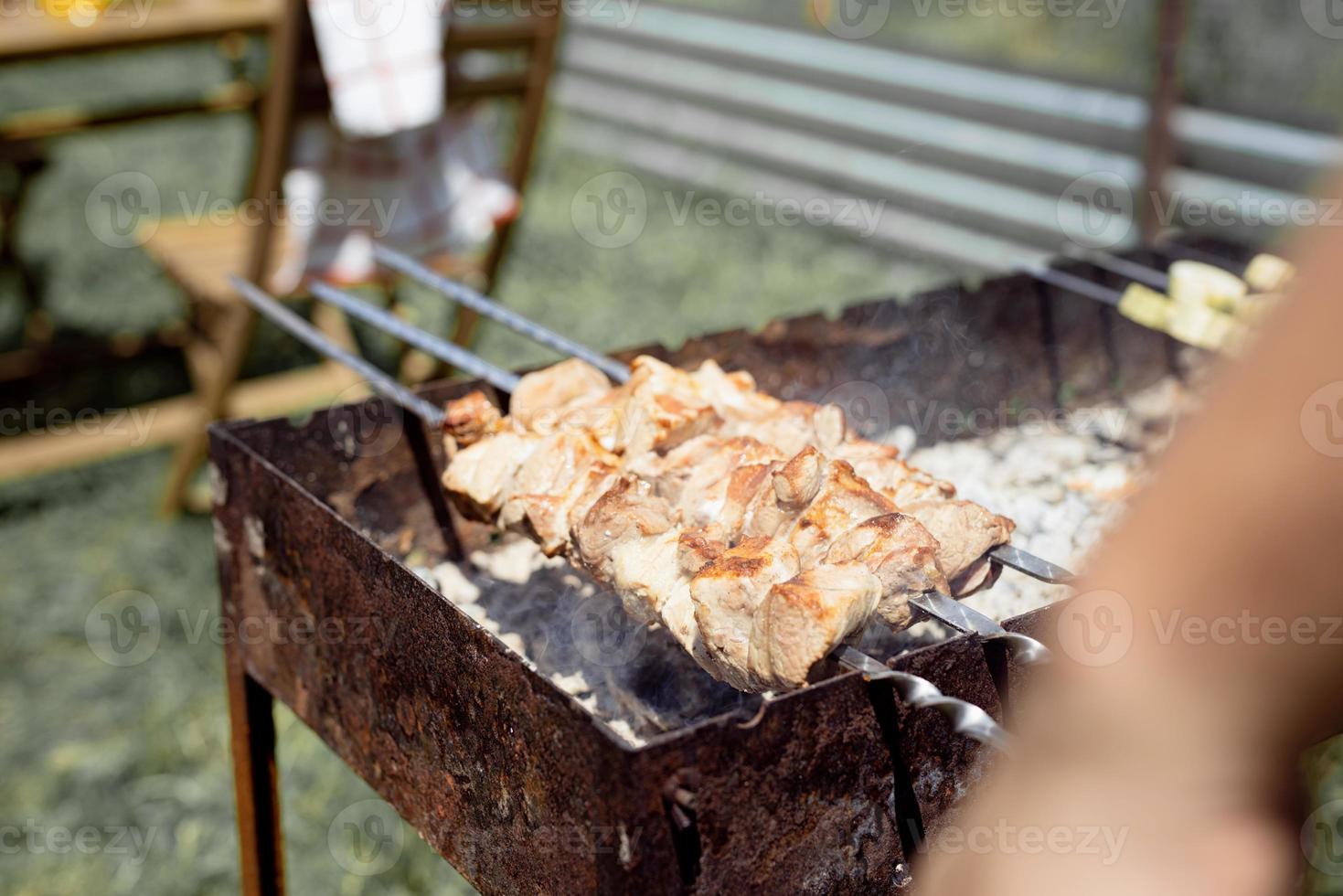 close up de kebabs em espetos, homem grelhando carne ao ar livre foto