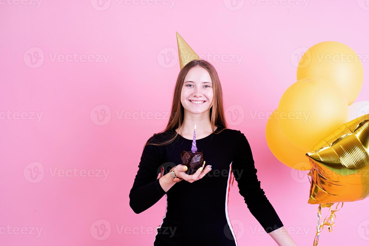 adolescente segurando um bolinho com velas, fazendo um pedido foto