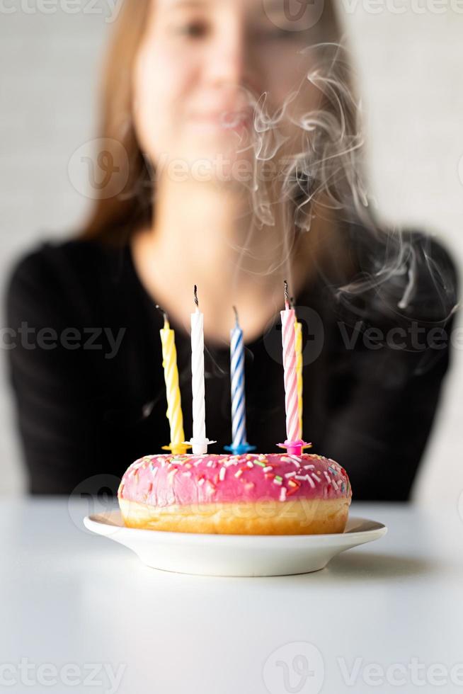 aniversariante adolescente soprando velas no donut foto