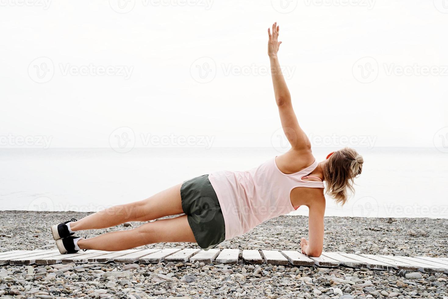 mulher atleta blong fazendo exercícios na praia foto