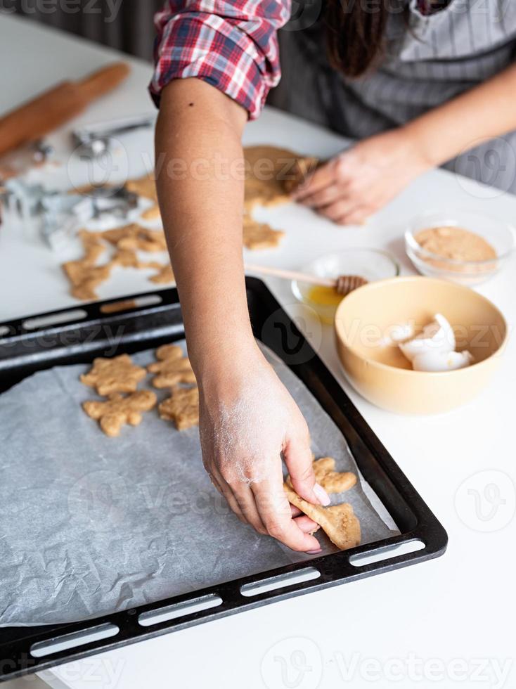 mulher com as mãos assando biscoitos na cozinha foto