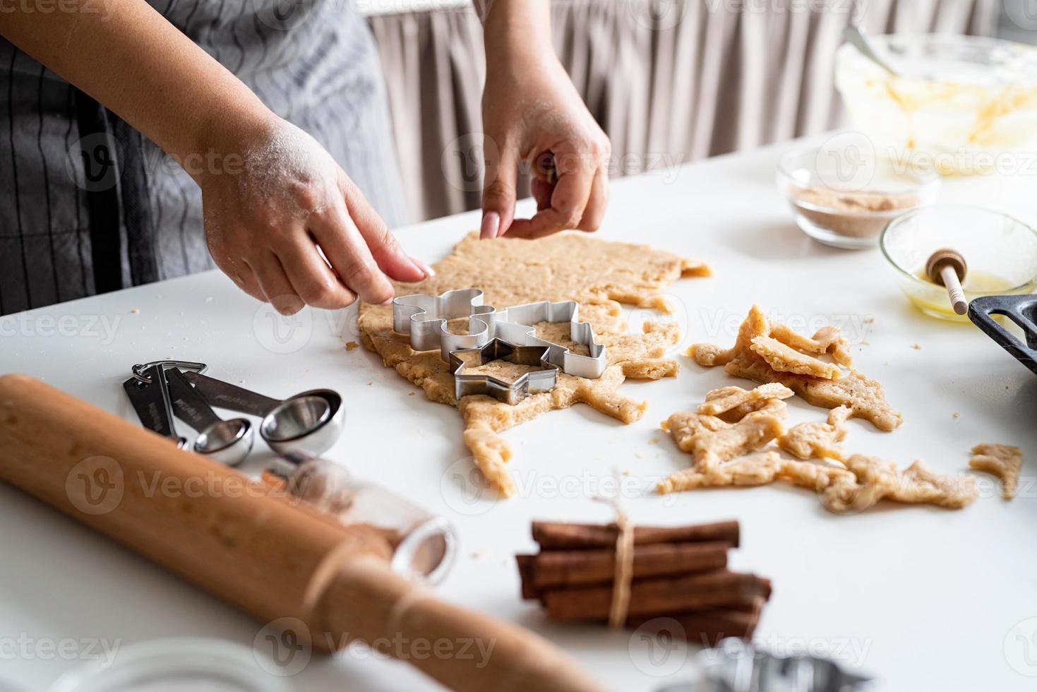 mulher com as mãos assando biscoitos na cozinha foto