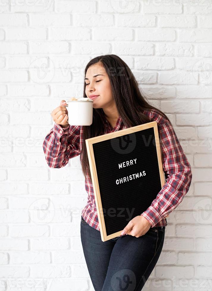 mulher com chapéu de Papai Noel com quadro de carta preto foto