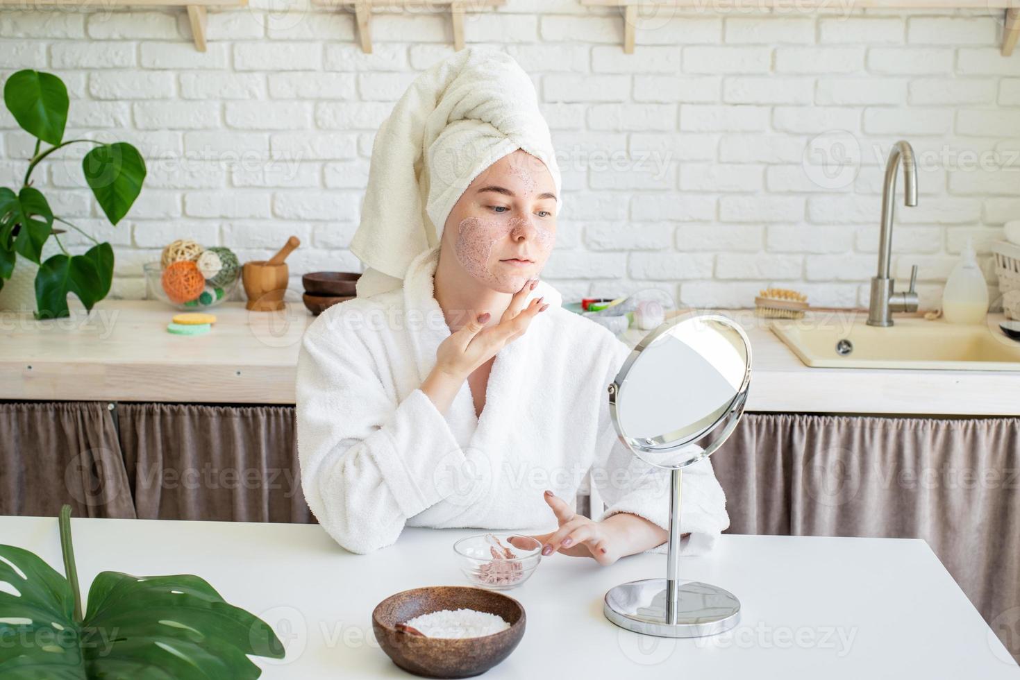 mulher aplicando creme facial em casa foto