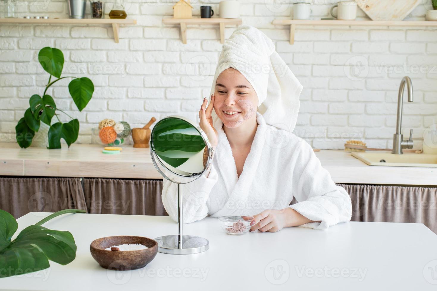 mulher aplicando creme facial em casa foto