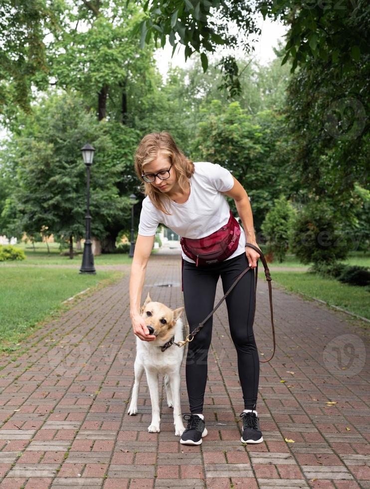 jovem treinando seu cachorro em um parque foto