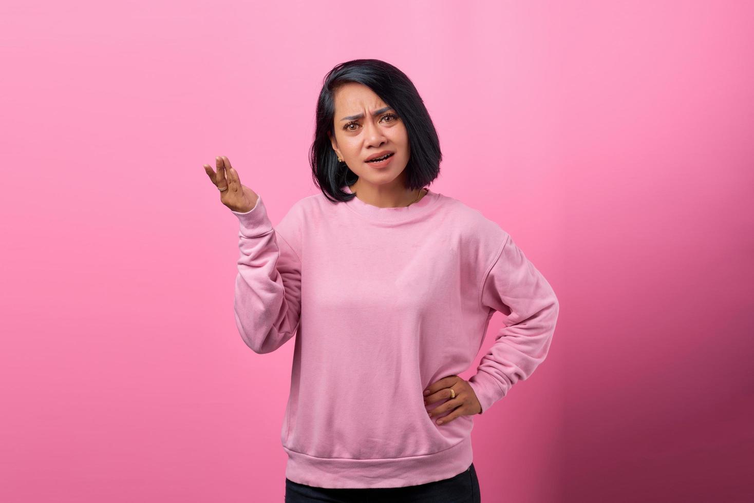 retrato de uma jovem asiática zangada levantando as palmas das mãos confusamente foto