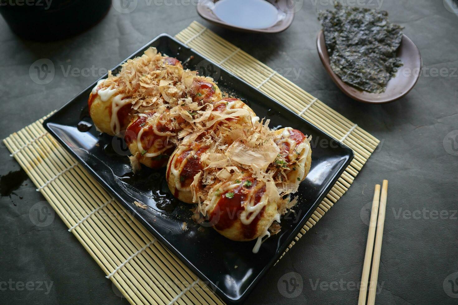 takoyaki é uma japonês comida, fez a partir de trigo farinha massa, polvo carne, ou de outros recheios, servido com molho, maionese e cobertura dentro a Formato do katsuobushi ou madeira peixe aparas de madeira. foto