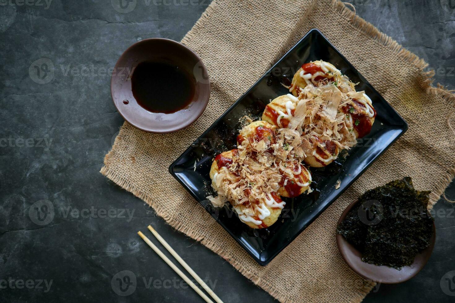 takoyaki é uma japonês comida, fez a partir de trigo farinha massa, polvo carne, ou de outros recheios, servido com molho, maionese e cobertura dentro a Formato do katsuobushi ou madeira peixe aparas de madeira. foto