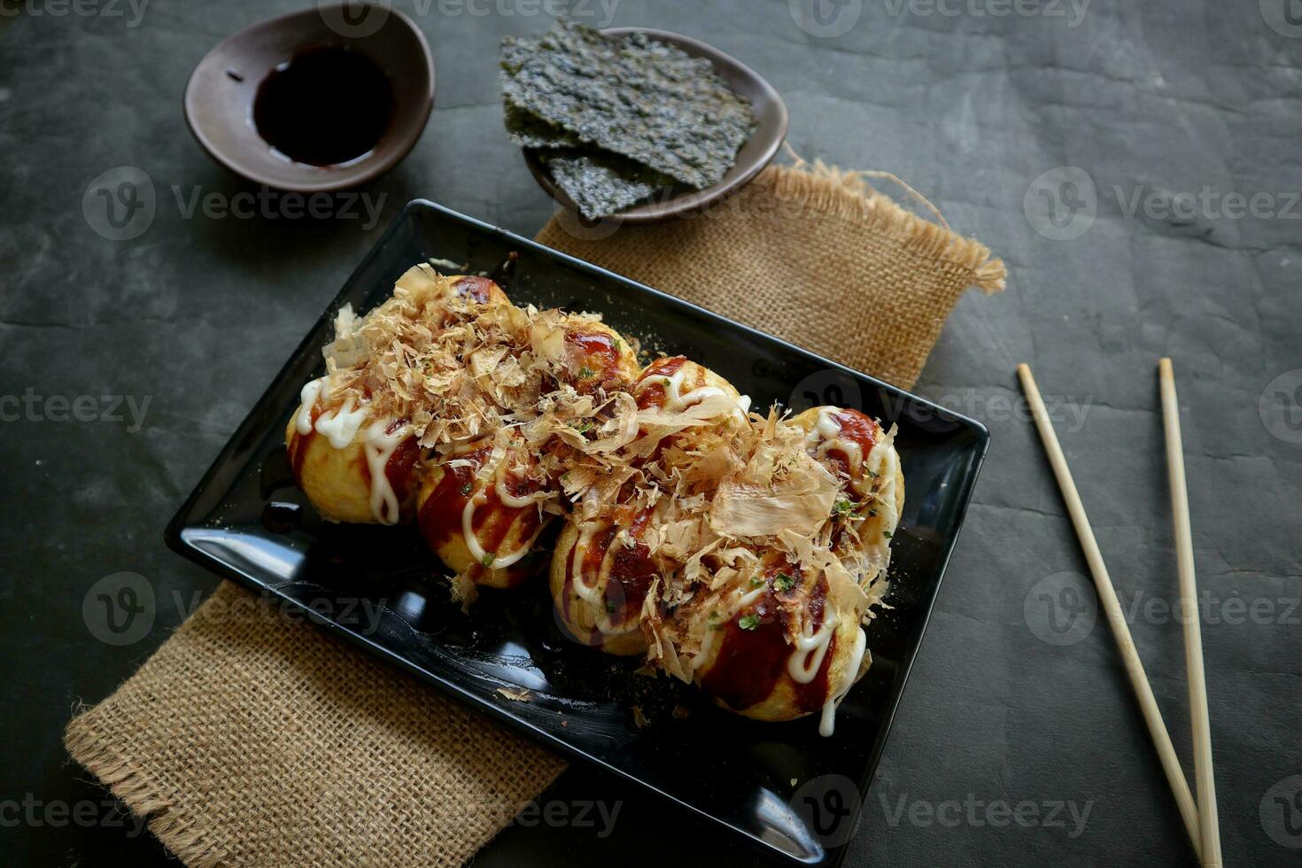 takoyaki é uma japonês comida, fez a partir de trigo farinha massa, polvo carne, ou de outros recheios, servido com molho, maionese e cobertura dentro a Formato do katsuobushi ou madeira peixe aparas de madeira. foto