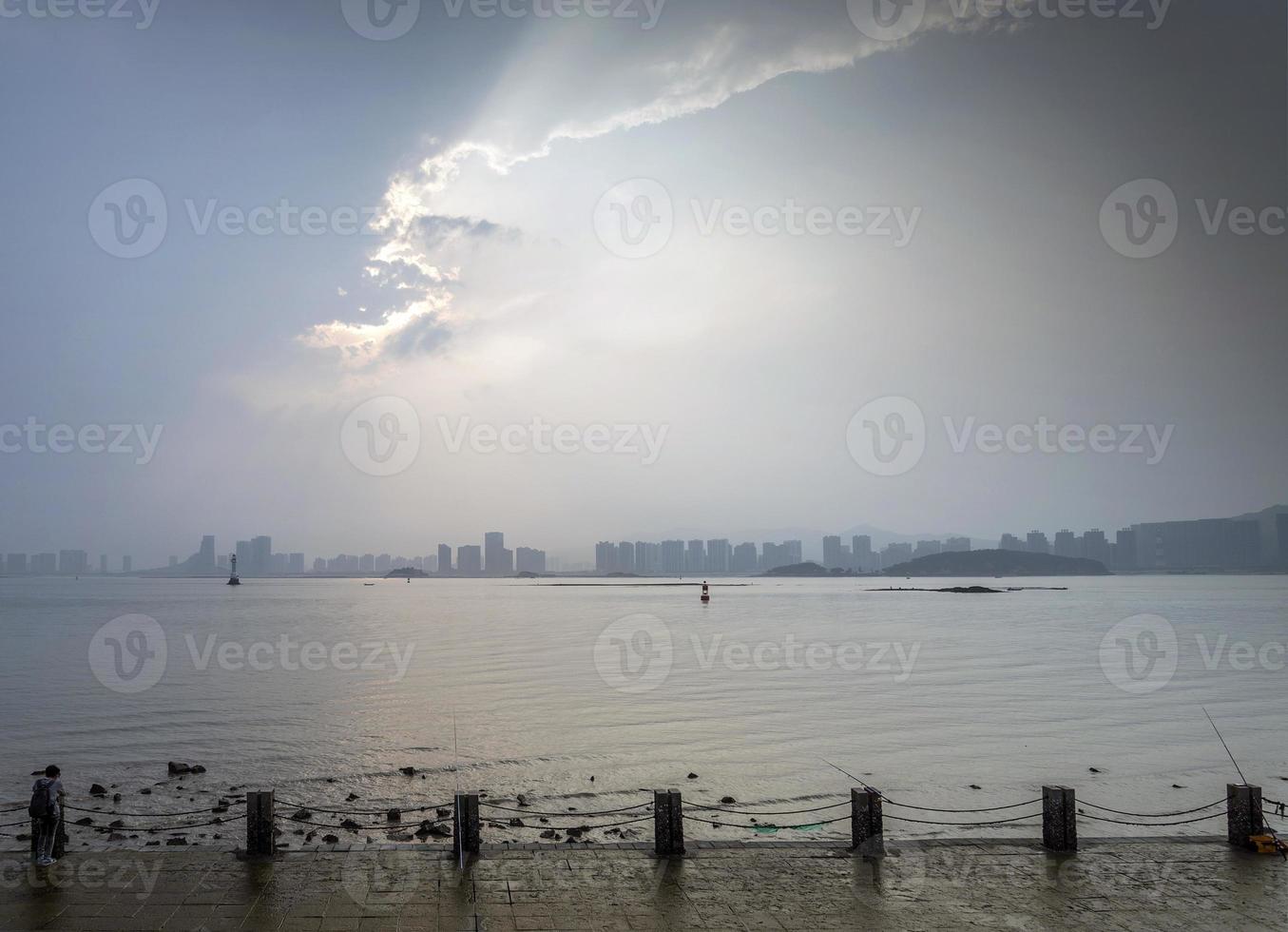 vista para o rio e o horizonte na cidade de xiamen, china, ao pôr do sol foto