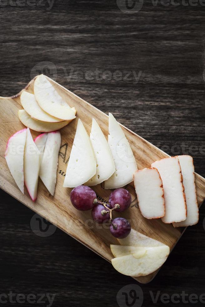 travessa de petisco de tapas de queijo português misto com conjunto de maçã e uvas foto