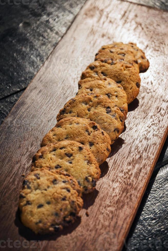 Biscoitos de biscoito de chocolate em tábua de madeira rústica foto