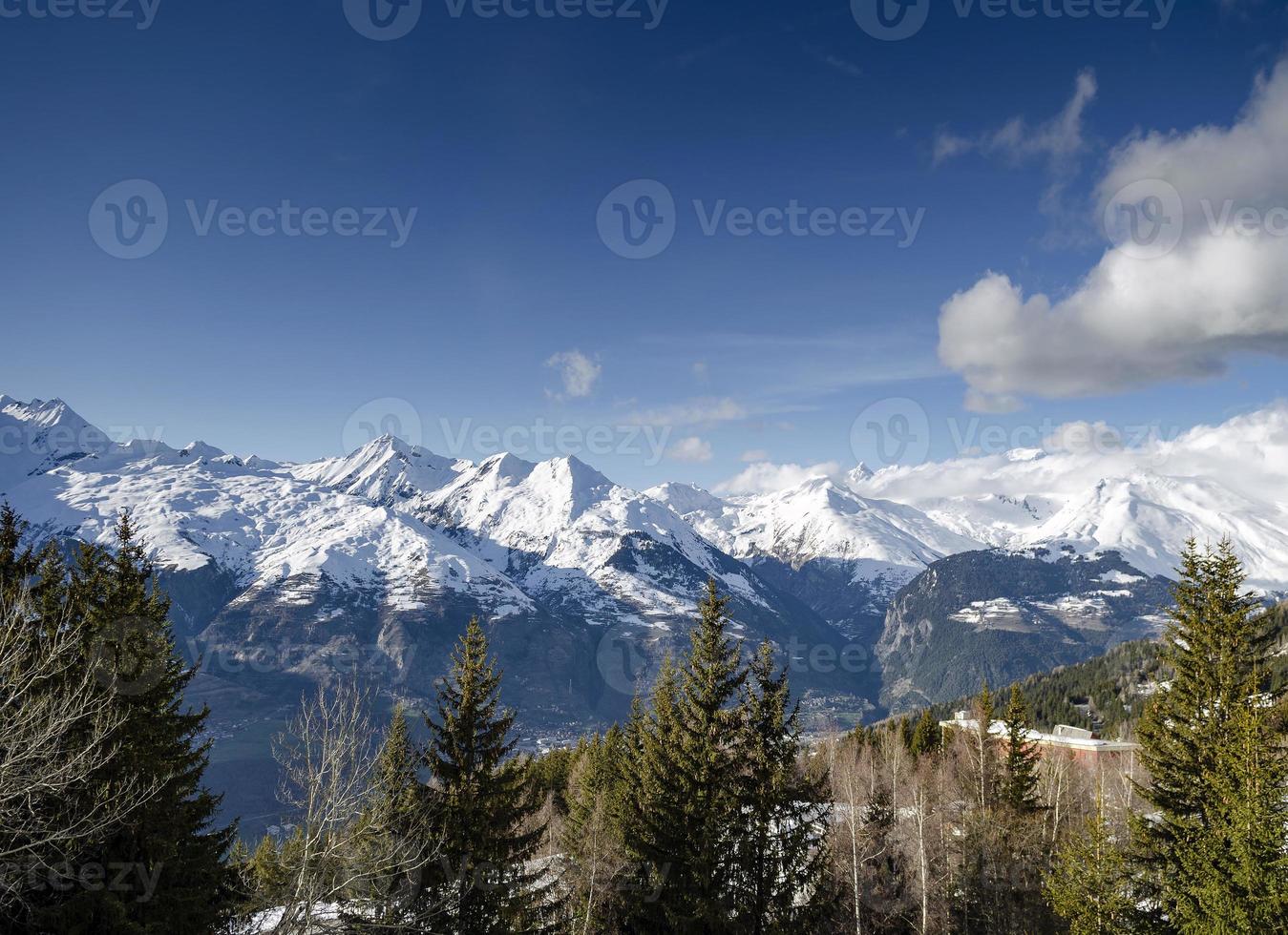 paisagem ensolarada de alpes franceses e montanha nevada na estação de esqui les arcs perto de bourg saint maurice, frança foto