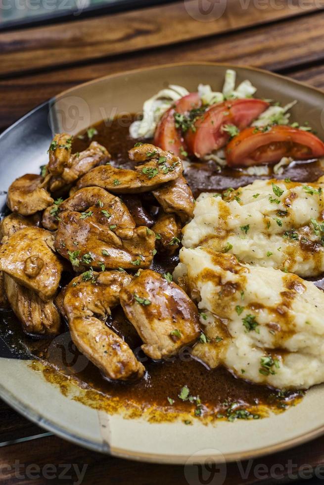 peito de frango com molho de carne e purê de batata foto