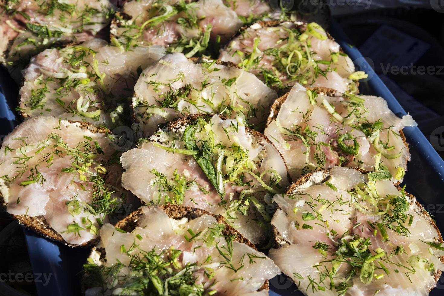 Mini sanduíche de filé de arenque escandinavo marinado fresco com endro no mercado de helsínquia foto