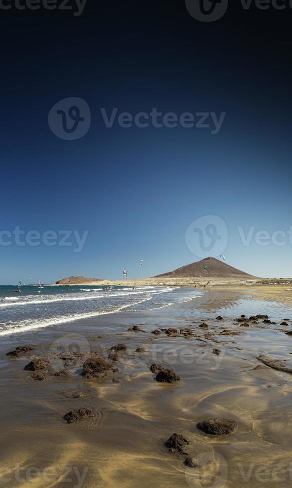 praia turística de el medano e paisagem famosa de montana roja em tenerife espanha foto