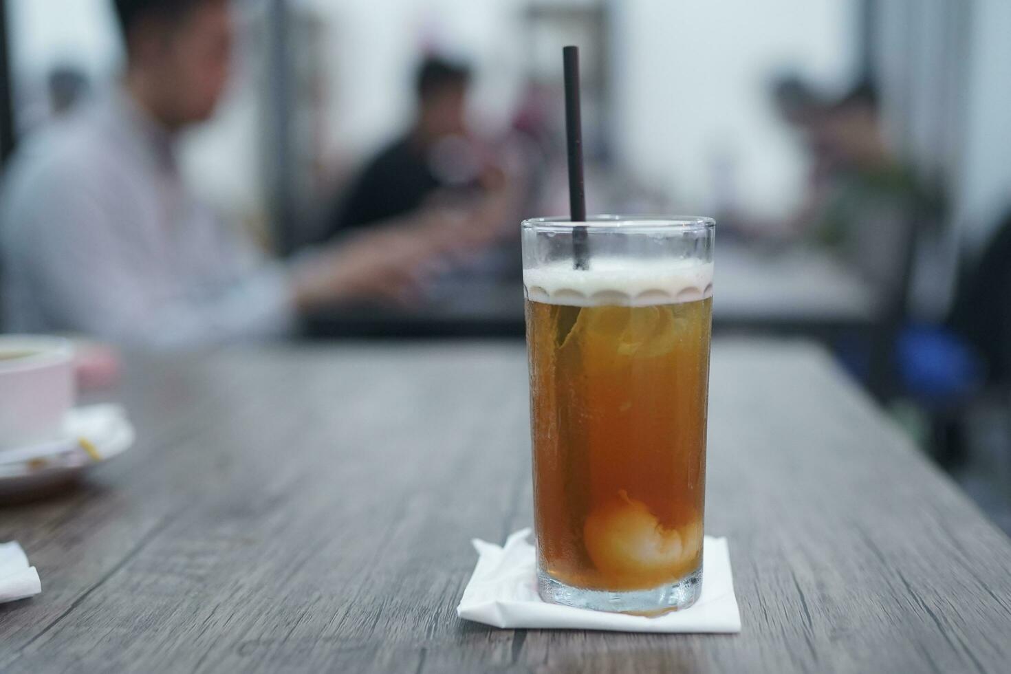 lichia chá ou lichia chá. gelado chá ou fresco beber dentro uma vidro com uma cafeteria fundo foto