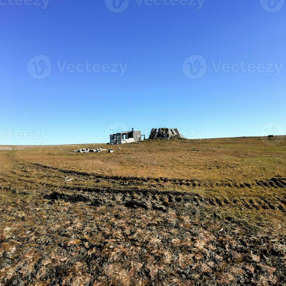 a velho de madeira estrutura em a ártico tundra fundo foto