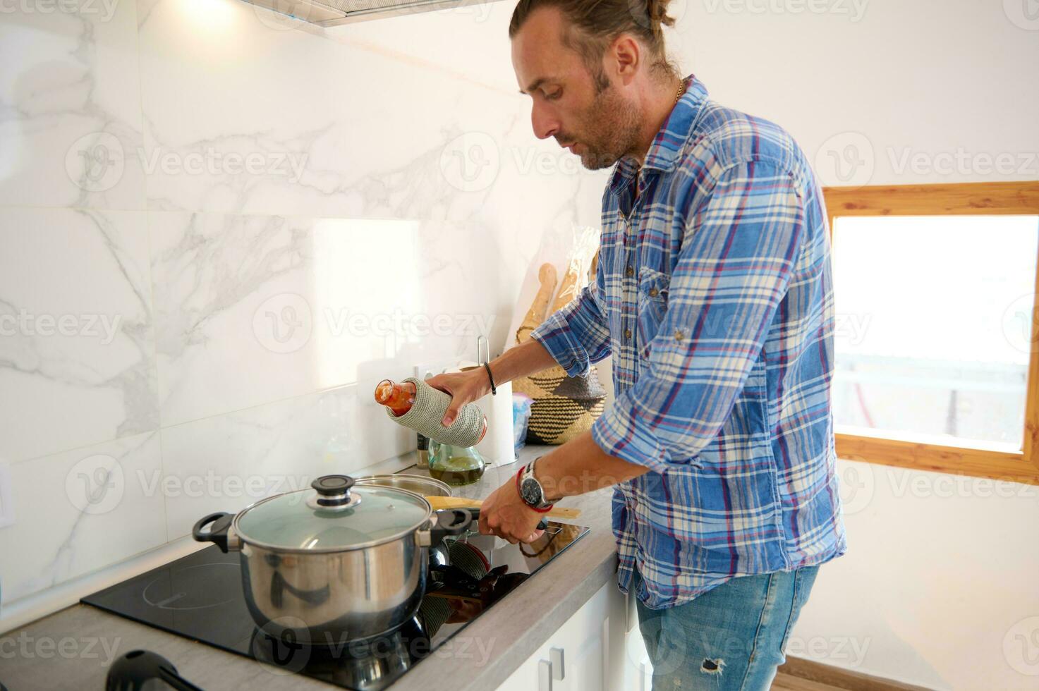 autêntico retrato do uma jovem adulto bonito homem cozinhando às casa foto