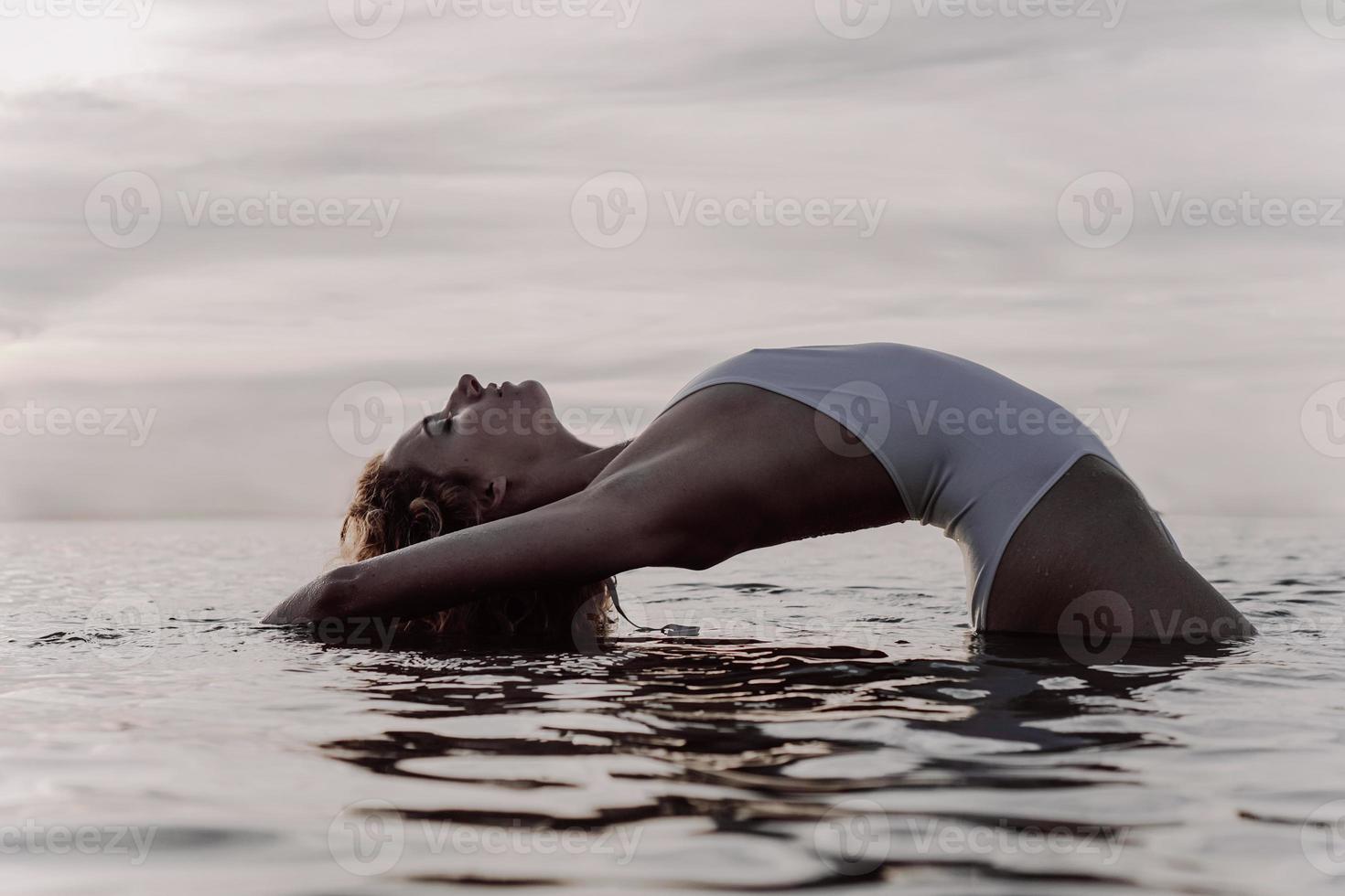 bela mulher sexy em um maiô branco posando perto do lago foto