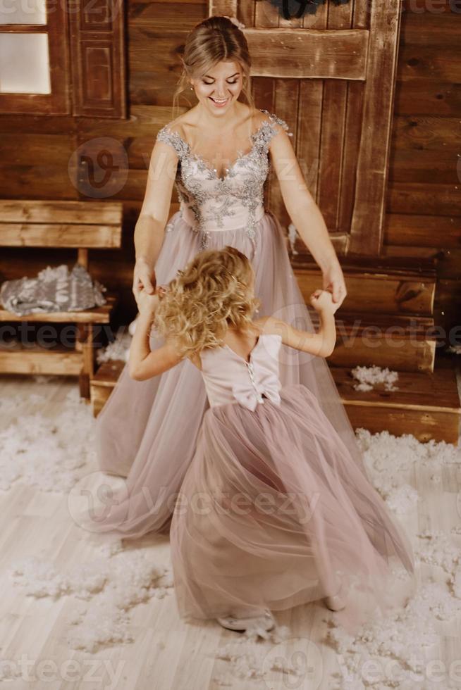 mãe e filha dançando em frente a uma decoração de natal foto