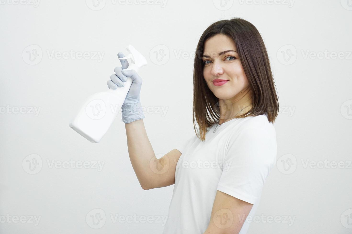 mulher segurando um frasco de spray - anti-séptico ou detergente como armas foto