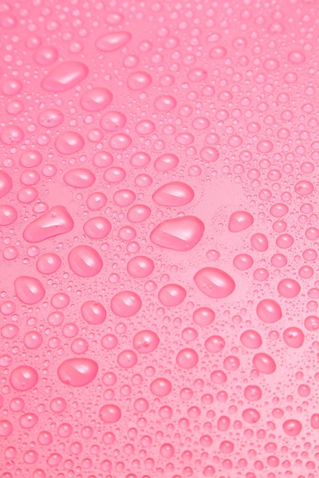 close-up gotas de água em fundo rosa foto