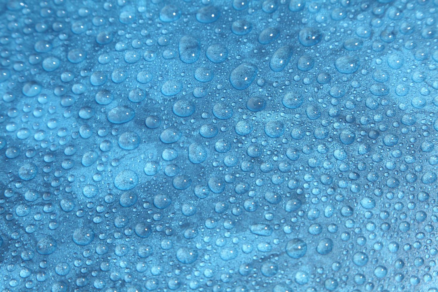 close-up gotas de água em fundo azul foto