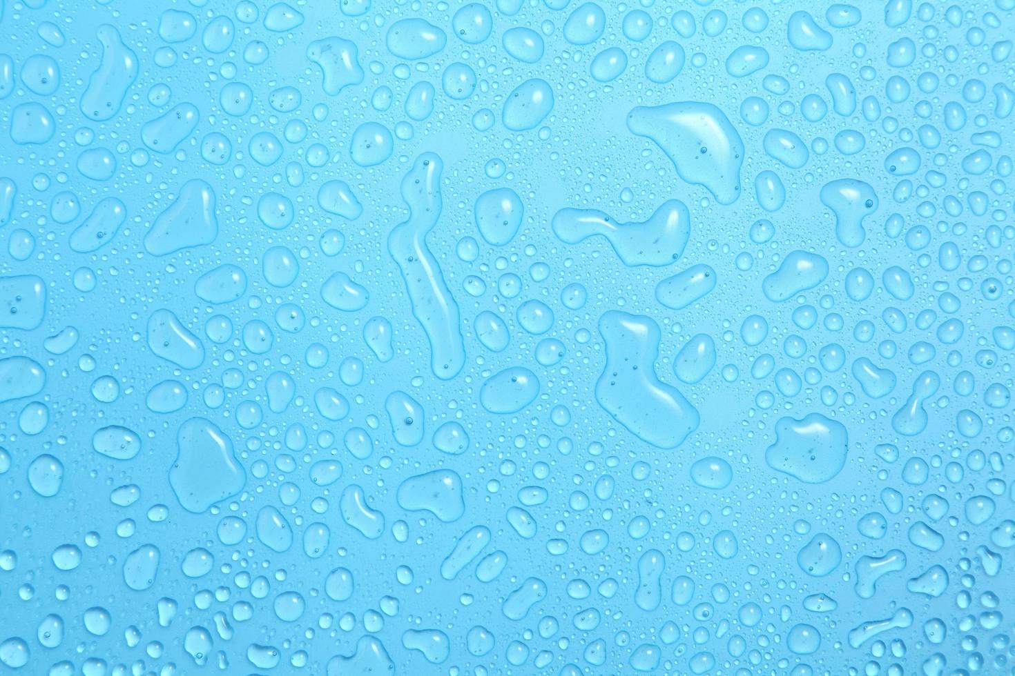 close-up gotas de água em fundo azul foto