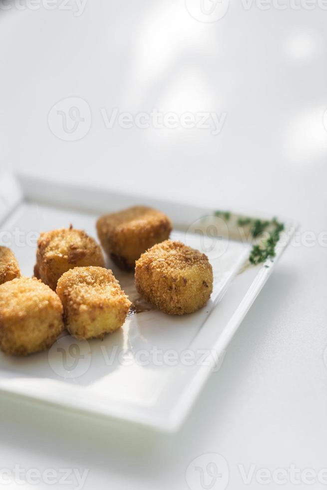 Croquetes de batata frita croquetas prato de entrada no fundo branco foto