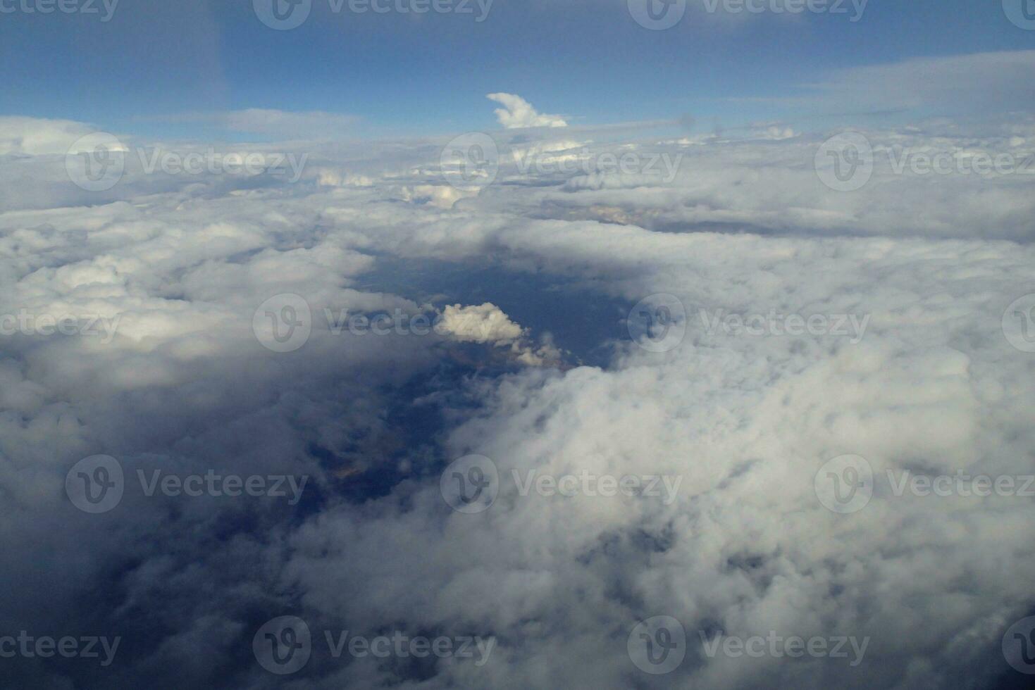 branco nuvens contra a azul céu visto a partir de a voar a partir de a janelas do a avião foto