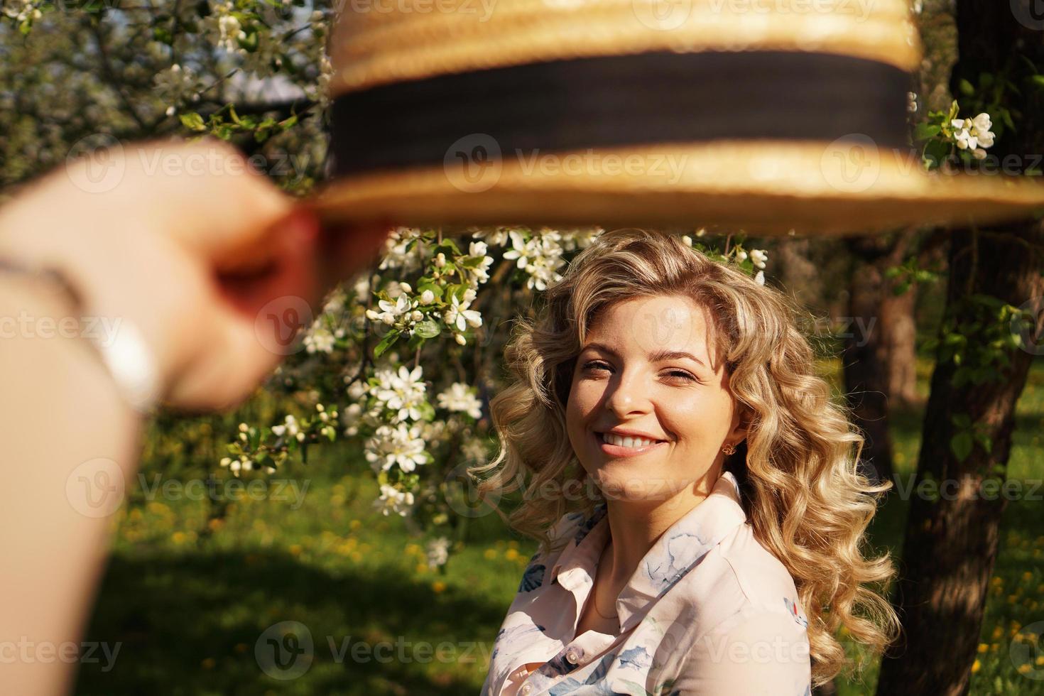 mulher sorridente de verão com chapéu de palha no parque foto