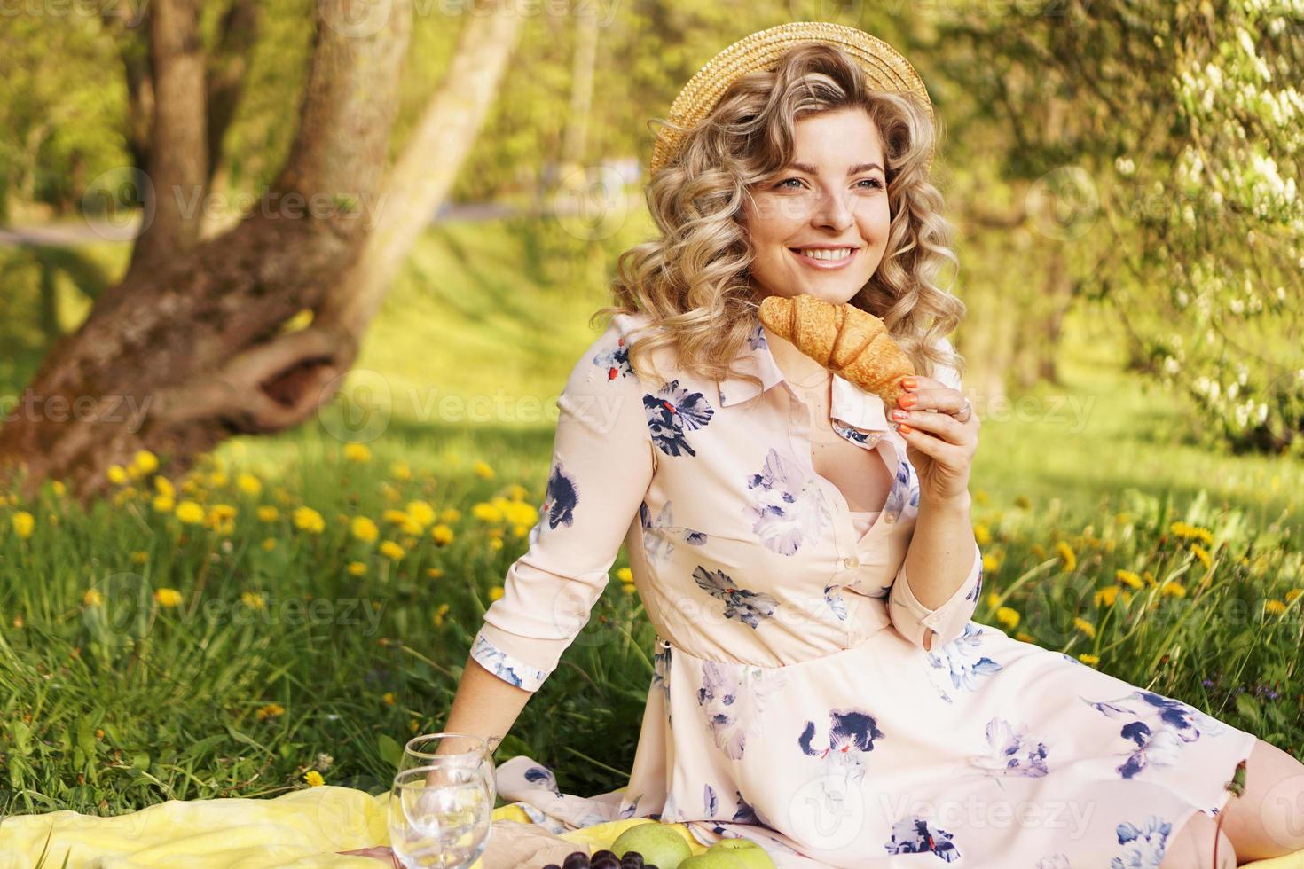 mulher com um croissant em um piquenique foto