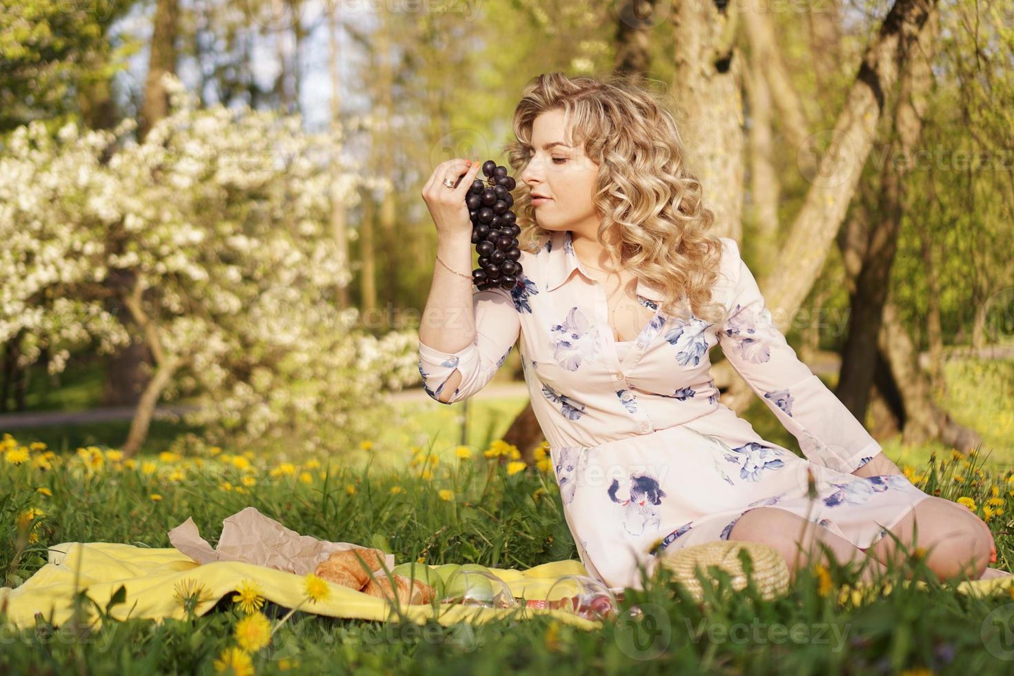 mulher com uva em um piquenique no jardim de verão foto