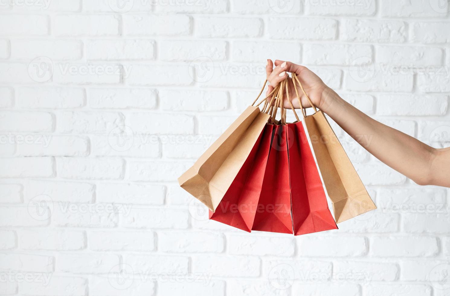 mão de uma mulher com sacolas de compras, texto preto sexta-feira em saco de papel foto