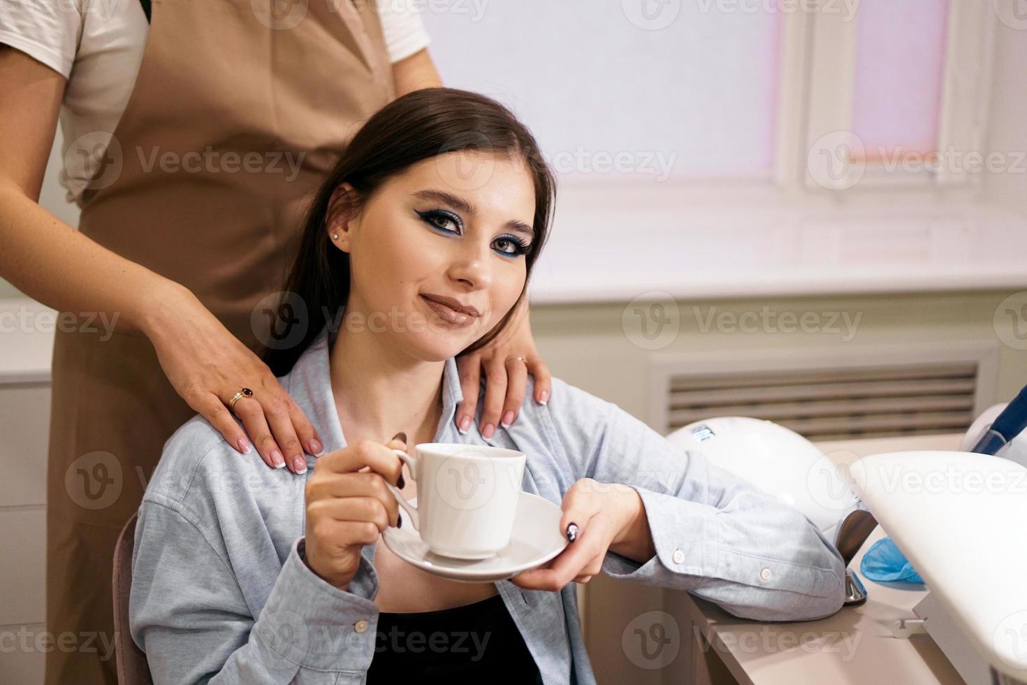 mulher fazendo manicure e massagem ao mesmo tempo em um salão de beleza foto