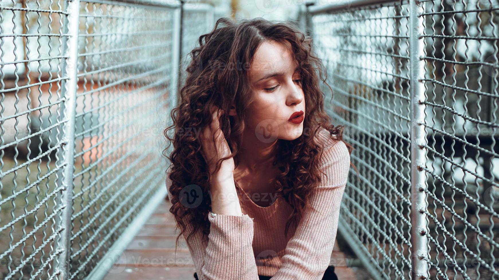 retrato da moda de mulher jovem e moderna sentada perto do rabitz de rede foto