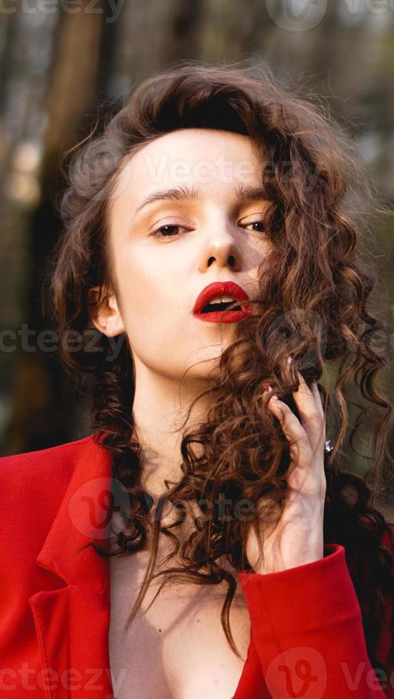 mulher glamorosa vestindo roupa vermelha e brilho labial vermelho combinando. foto
