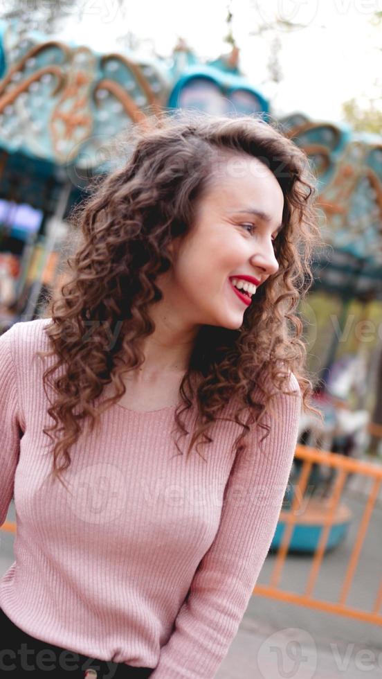 garota relaxando no parque de diversões na manhã de fim de semana. modelo risonho foto