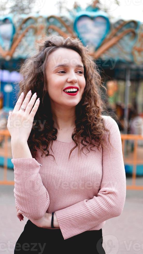 garota relaxando no parque de diversões na manhã de fim de semana. modelo risonho foto